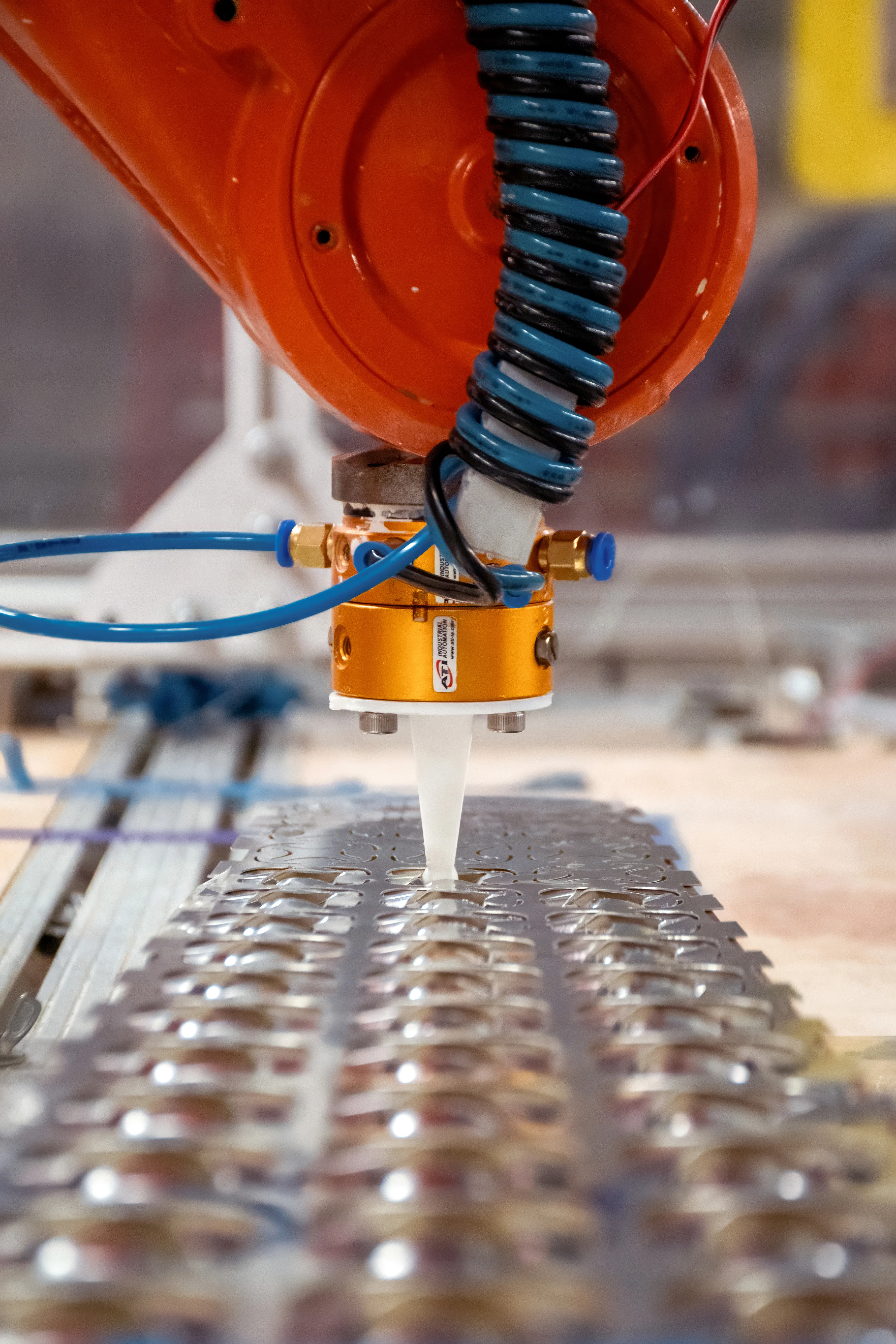 The robotic arm deforming an aluminum cell.