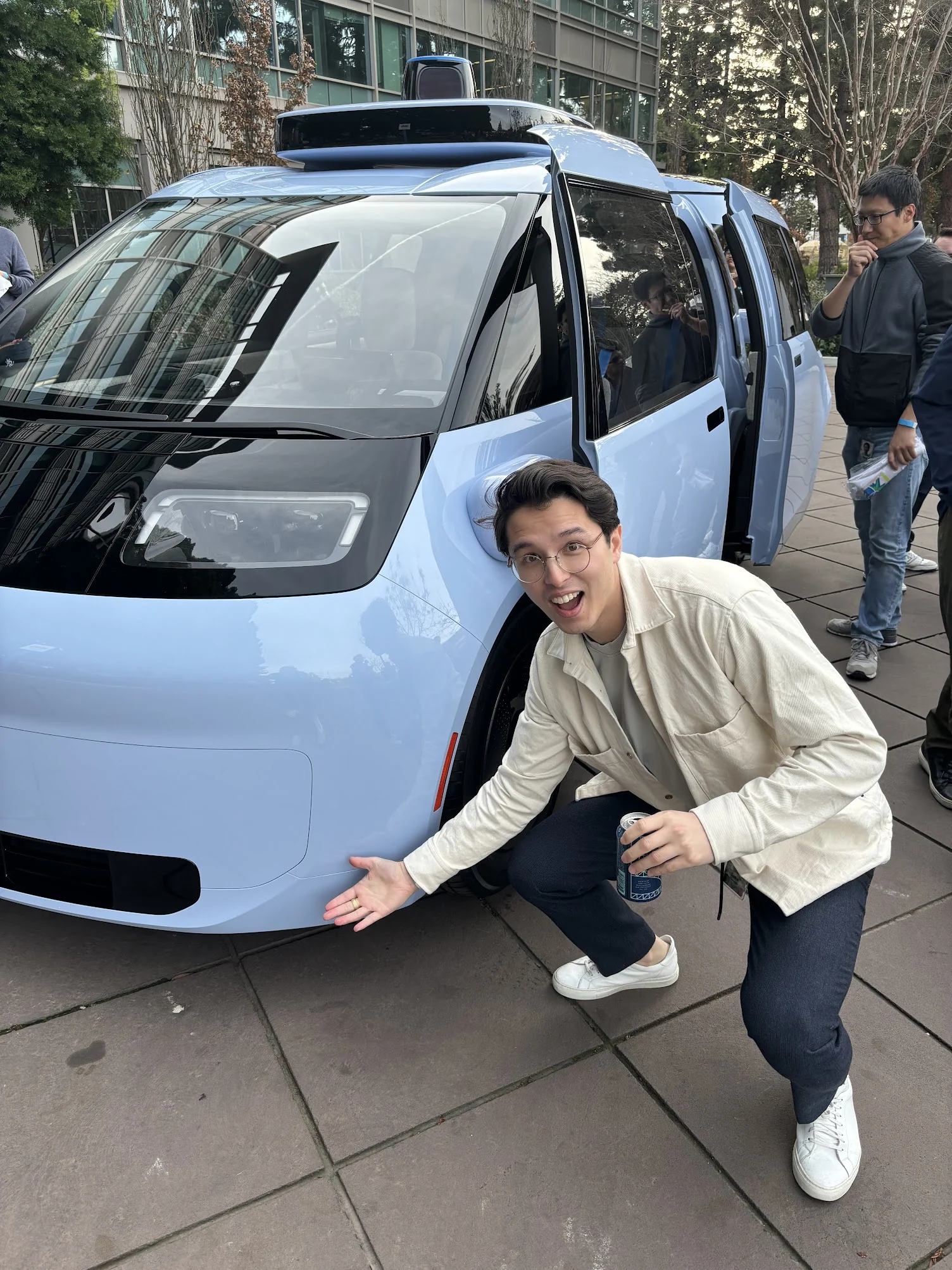 Luke Fiorante beside a Waymo prototype vehicle